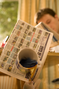 Busy Bees partner with Child Accident Prevention Trust (CAPT) to promote Child Safety Week Campaign, picture shows Hot Coffee falling towards a childs hand as they pull a newspaper that the cup is sitting on