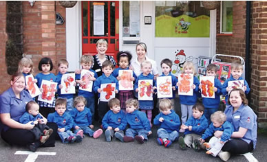 Busy Bees Children pictured holding up letters to spell the word 'outstanding' after their nursery attained an award from Ofsted at the same 'Outstanding' level