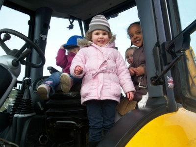 Children playing on a digger during Digger Day at their Peterborough childrens nursery