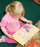 A little girl reading at her childrens nursery