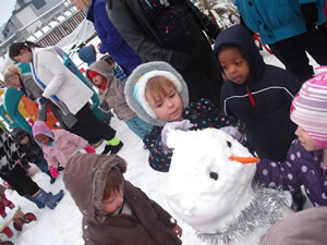 Children at nursery playing in the snow