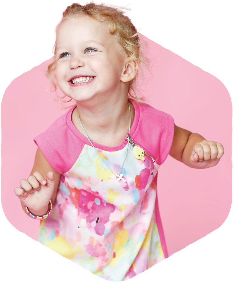 Little girl in pink and pastel coloured dress wiggling and dancing