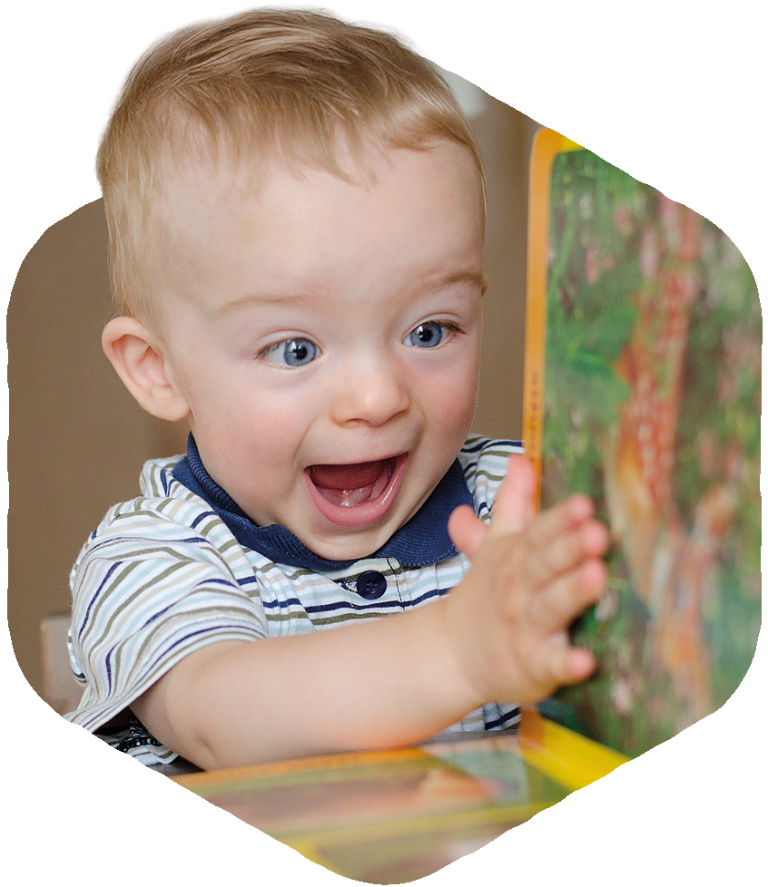 Excited young boy looking at pictures in a childrens book