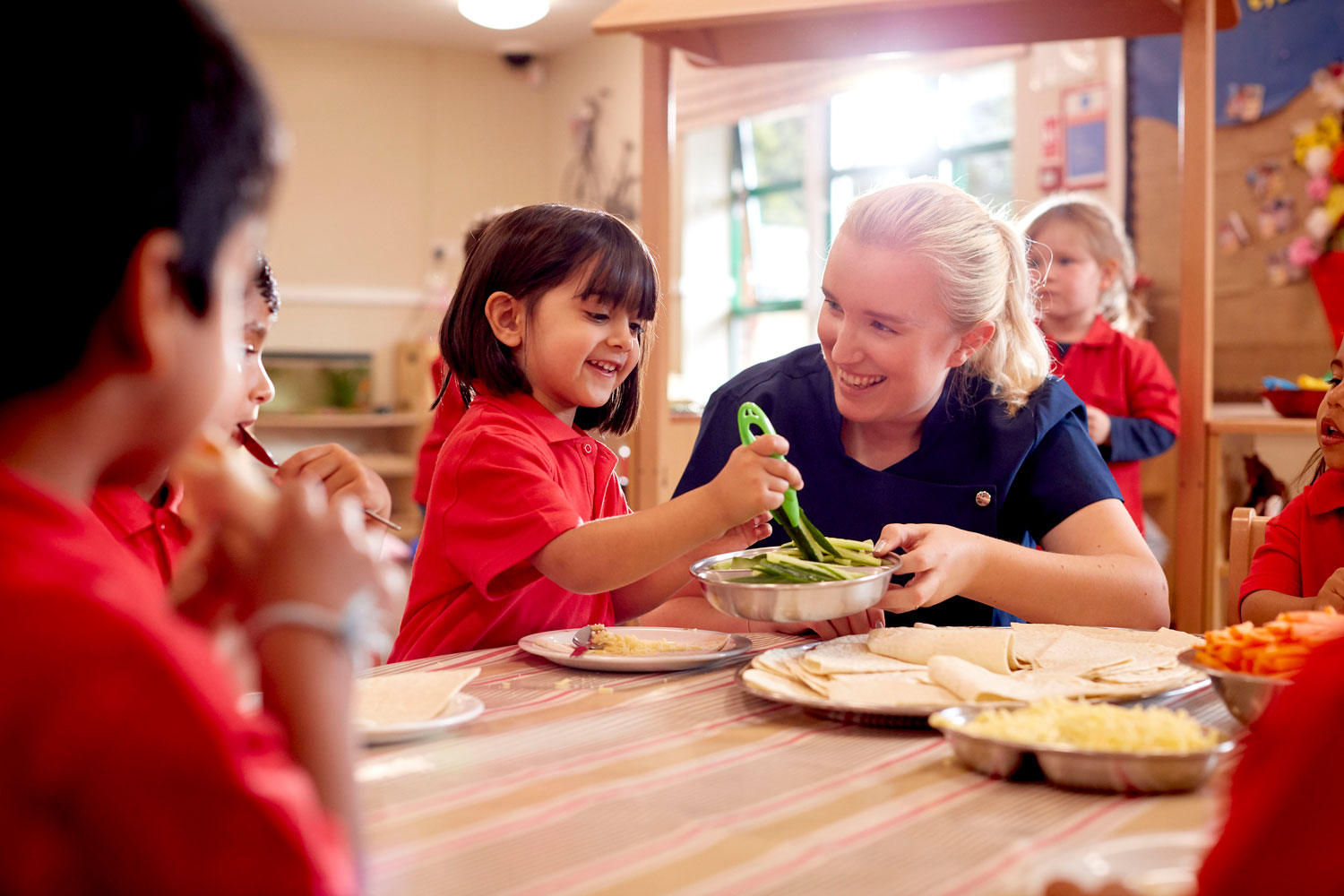 Child cooking with a member of staff