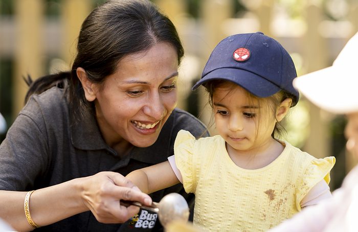 A practitioner playing outdoors with a toddler.